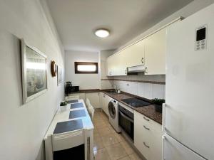 a kitchen with white cabinets and a sink and a dishwasher at Precioso y Luminoso Piso in Garachico