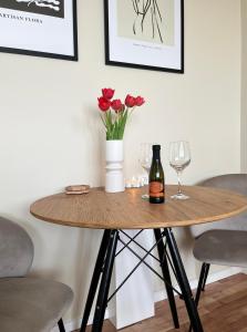 a table with a bottle of wine and flowers on it at Elegant studio close to the city centre in Bratislava