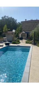 een zwembad met blauw water in een tuin bij Maison avec piscine in Saint-Pierre-de-Boeuf