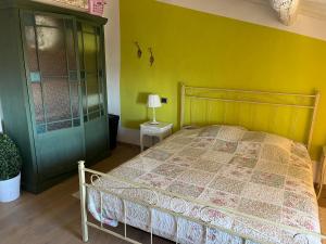 een slaapkamer met een bed en een groene deur bij Rifugio Romantico in Castagneto Carducci