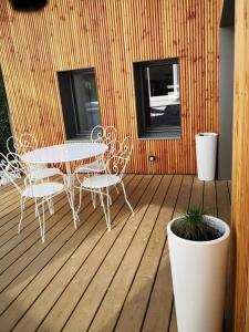 a patio with a table and chairs on a wooden deck at cottage du Fort Ambleteuse in Ambleteuse +3 photos