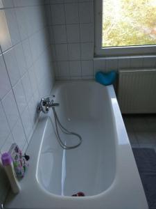 a white bath tub with a faucet in a bathroom at Gästewohnung von J&O am Fluss. in Jork