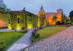 an ivy covered building with a castle in the background at Monet Business Grade Apartment: ideal for Digital Nomads, MedTourist, Wellness in Belgrade