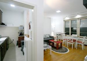 a kitchen and a living room with a table and chairs at Monet Business Grade Apartment: ideal for Digital Nomads, MedTourist, Wellness in Belgrade