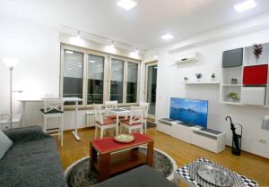 uma sala de estar com um sofá e uma mesa em Monet Business Grade Apartment: ideal for Digital Nomads, MedTourist, Wellness em Belgrado