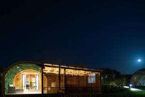 a small house with a lit up facade at night at Glen Getaway - (Luxury Pod) in Stranraer
