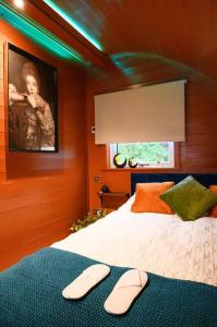 a bedroom with a bed with two slippers on it at Glen Getaway - (Luxury Pod) in Stranraer