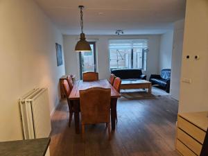 een eetkamer en een woonkamer met een tafel en stoelen bij Residence Dordrecht - 10 persons in Dordrecht