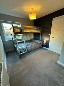 a bedroom with a bunk bed and a ladder at Elwood - spacious contemporary home from home in Harrogate with parking in Harrogate