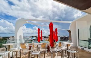 balkon ze stołami i krzesłami oraz widokiem na miasto w obiekcie Alizee Tower w mieście Playa del Carmen