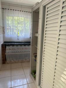 ein Zimmer mit einem Fenster mit Jalousien an der Tür in der Unterkunft casa indisponivel in Caraguatatuba