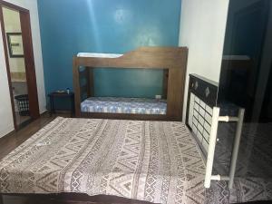 ein Schlafzimmer mit einem Bett und einem Teppich auf dem Boden in der Unterkunft casa indisponivel in Caraguatatuba