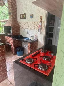 einen roten Herd mit Backofen in der Küche in der Unterkunft casa indisponivel in Caraguatatuba
