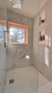 baño con ducha y puerta de cristal en Nature Eco Suite in Wakefield Quebec, en Wakefield