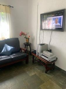 Chácara Recanto Florido في سوزانو: غرفة معيشة مع أريكة وتلفزيون