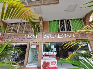 een winkel voor een gebouw met palmbomen voor de deur bij HOTEL DULCES SUEÑOS in Buenaventura