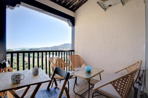 eine Terrasse mit 2 Tischen und Stühlen sowie einen Balkon in der Unterkunft Appartement cosy climatisé à 100m des plages in Gassin