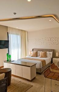1 dormitorio con 1 cama grande y espejo grande en Alizee Tower en Playa del Carmen