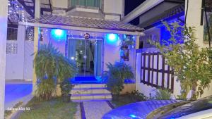 dom z niebieskimi światłami na drzwiach wejściowych w obiekcie Pousada Kekas w mieście Duque de Caxias