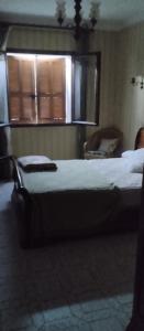 1 Schlafzimmer mit 2 Betten und einem Fenster in der Unterkunft Maison en pierre de taille in Petreto-Bicchisano