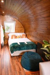 ein Schlafzimmer mit einem Bett in einer Holzhütte in der Unterkunft Bonnie Brae - (Luxury Pod) in Portpatrick