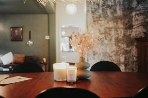 a wooden table with a vase and two candles on it at « L’Écluse Simon » in Tilff