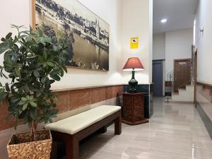 a waiting room with a bench and a potted plant at Studio City Center - Aloha Sevilla in Seville