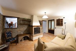 sala de estar con sofá y chimenea en Borgo di Porciano Casa Elisabetta en Stia