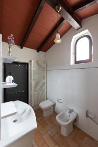 baño con 2 lavabos, aseo y ventana en Borgo di Porciano Casa Elisabetta en Stia