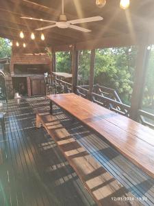 a large wooden table on a deck with a fireplace at Cabaña del rio Paraná in Puerto Iguazú