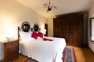1 dormitorio con 1 cama blanca grande con almohadas rojas en Borgo di Porciano Casa Elisabetta en Stia