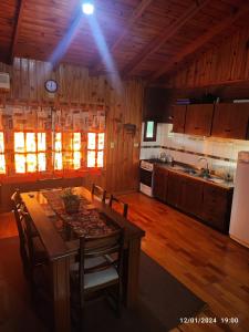 una cucina con tavolo in legno e una cucina con frigorifero di Cabaña del rio Paraná a Puerto Iguazú
