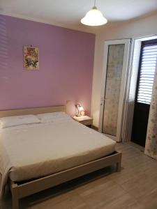um quarto com uma cama e uma parede roxa em B&B RIPALTA em Sogliano al Rubicone
