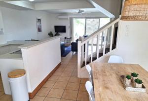 uma cozinha e sala de jantar com uma mesa e uma escada em Isle of Palms 31 em Gold Coast