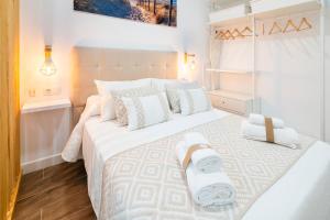 a bedroom with a white bed with two towels on it at Loft Premium Córdoba in Córdoba