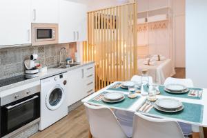 a kitchen with a table and a washing machine at Loft Premium Córdoba in Córdoba