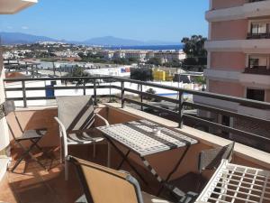 balcón con mesa, sillas y teclado en Apartamento Manilva con terraza y piscina, en Manilva