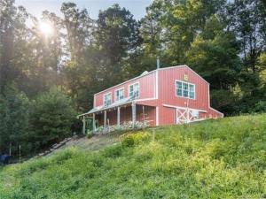 a red barn sitting on top of a hill at The Barn At Slick Rock in Hendersonville