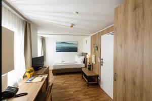 1 dormitorio con 1 cama y escritorio con ordenador en Heilmoorbad Schwanberg, en Schwanberg