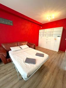sypialnia z łóżkiem i czerwoną ścianą w obiekcie Bohemian Apartments near the Center w Pradze