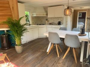 ヌンスペートにあるNEW: recent opgeknapte houten chalet - de Veluweのキッチン(白いテーブル、椅子付)