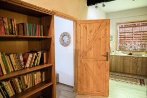 a room with a door and shelves of books at Queen's Garden Dom Nad Stawem in Rypin