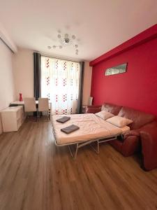 a bedroom with a couch and a red wall at Bohemian Apartments near the Center in Prague