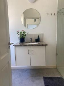a bathroom with a sink and a mirror at Sunset Studio in Cape Town
