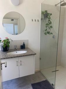 a bathroom with a sink and a shower with a mirror at Sunset Studio in Cape Town