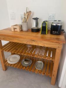 a wooden shelf with plates and utensils on it at Sunset Studio in Cape Town