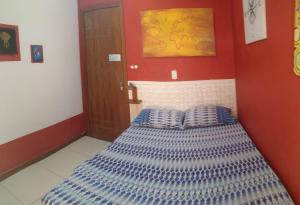 a bedroom with a bed with blue and white pillows at Odoya Guest House in Salvador