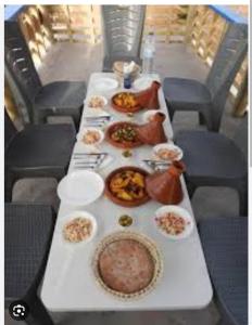 een lange tafel met borden eten erop bij Casa de campo in Al Hoceïma