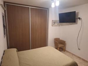 a bedroom with a bed and a television on the wall at Casa Frente Dique Piedras Moras in Almafuerte