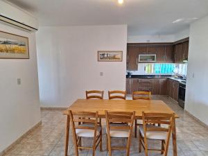 a kitchen with a wooden table and chairs at Casa Frente Dique Piedras Moras in Almafuerte